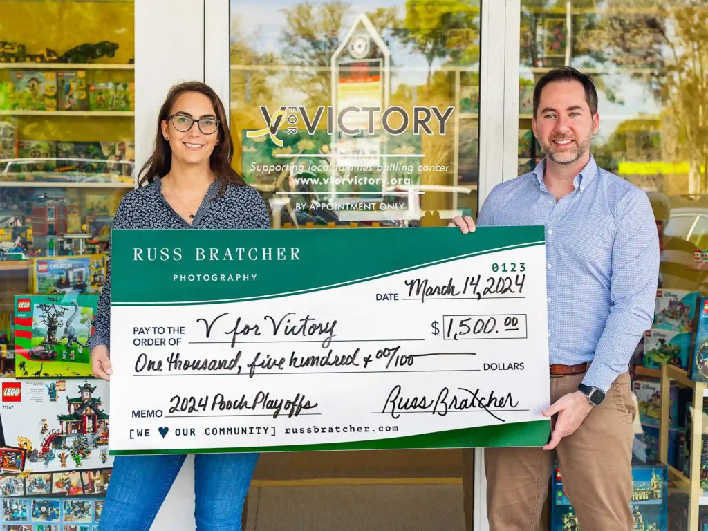 Photographer Russ Bratcher presenting donation check to charity